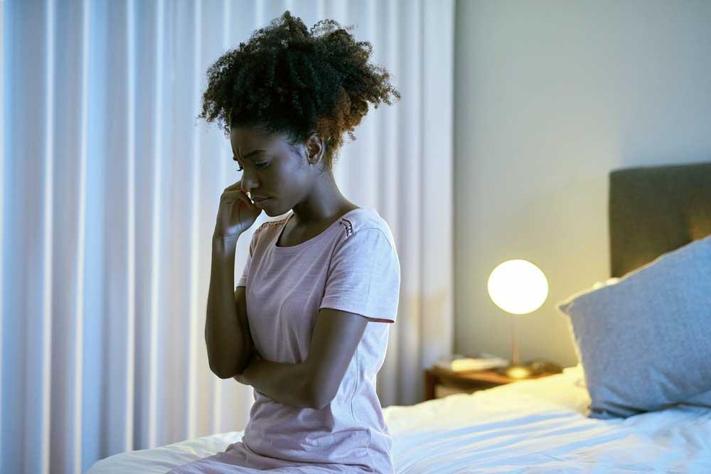 frustrated woman sitting on her bed